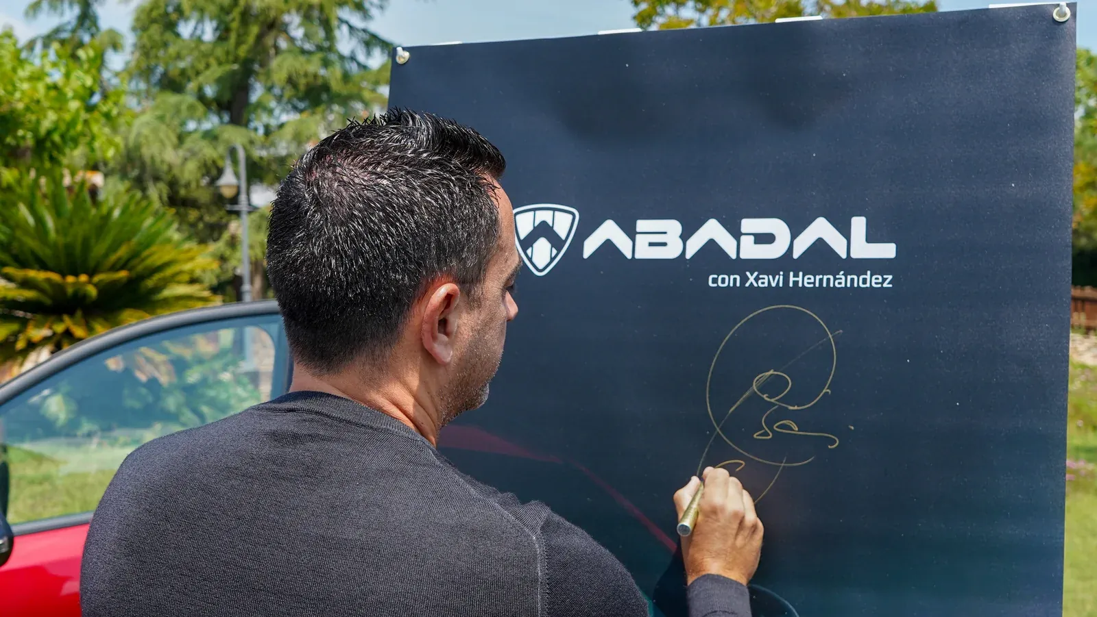 Xavi Hernández firmando el cartel oficial ABADAL